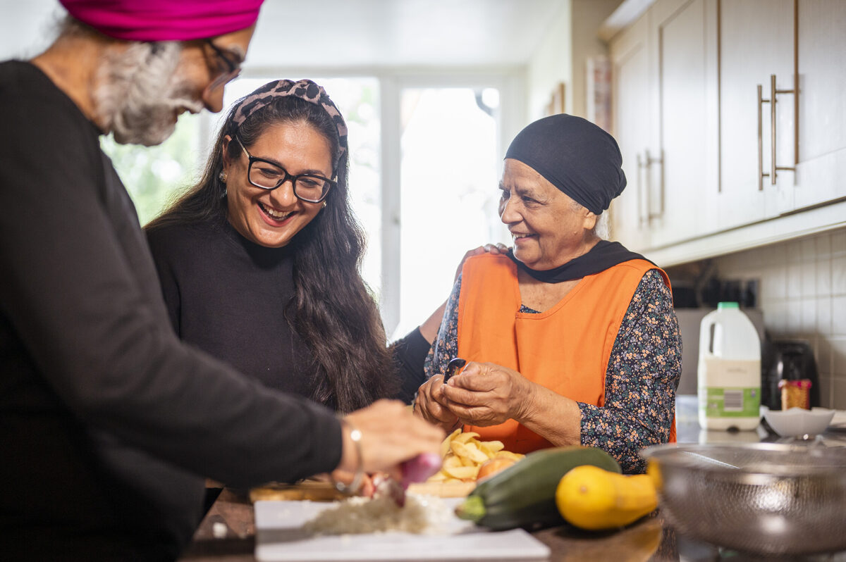 Group of people preparing fresh vegetables in a kitchen